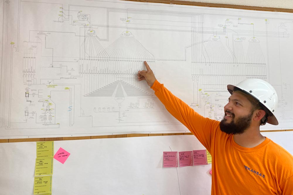 Kansas Electric manager pointing at a wiring diagram