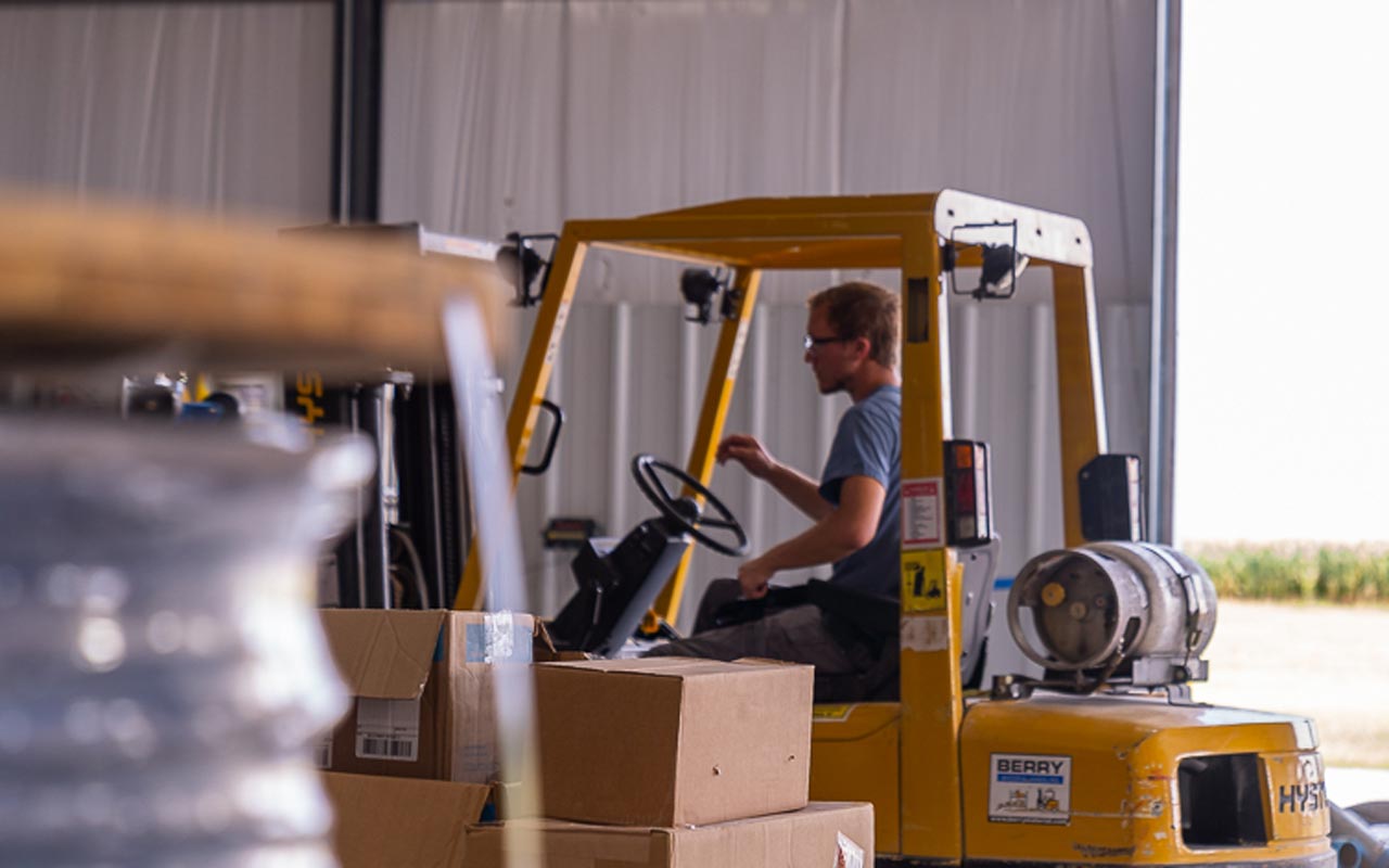 Kansas Electric employees driving a yellow forklift
