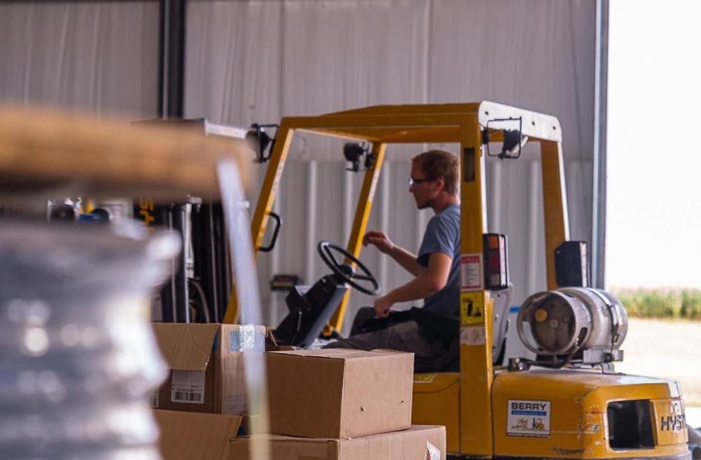 A person driving a forklift in a warehouse